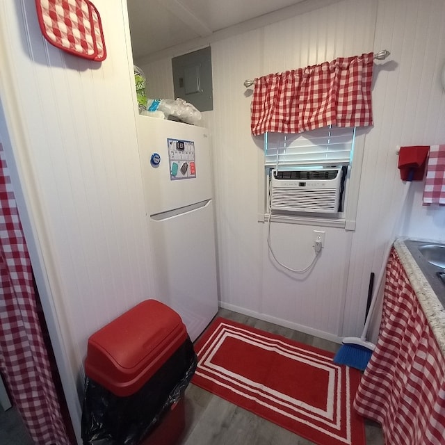 doorway to outside featuring hardwood / wood-style floors, electric panel, cooling unit, and wood walls