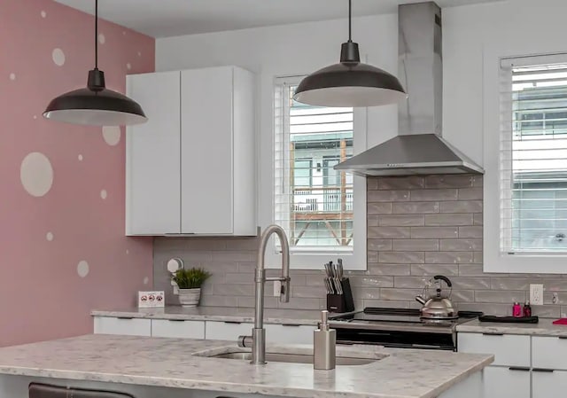 kitchen with white cabinetry, pendant lighting, tasteful backsplash, and wall chimney exhaust hood