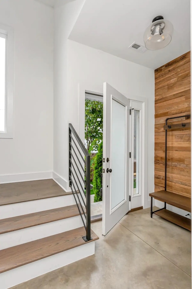 foyer featuring a wealth of natural light and wooden walls