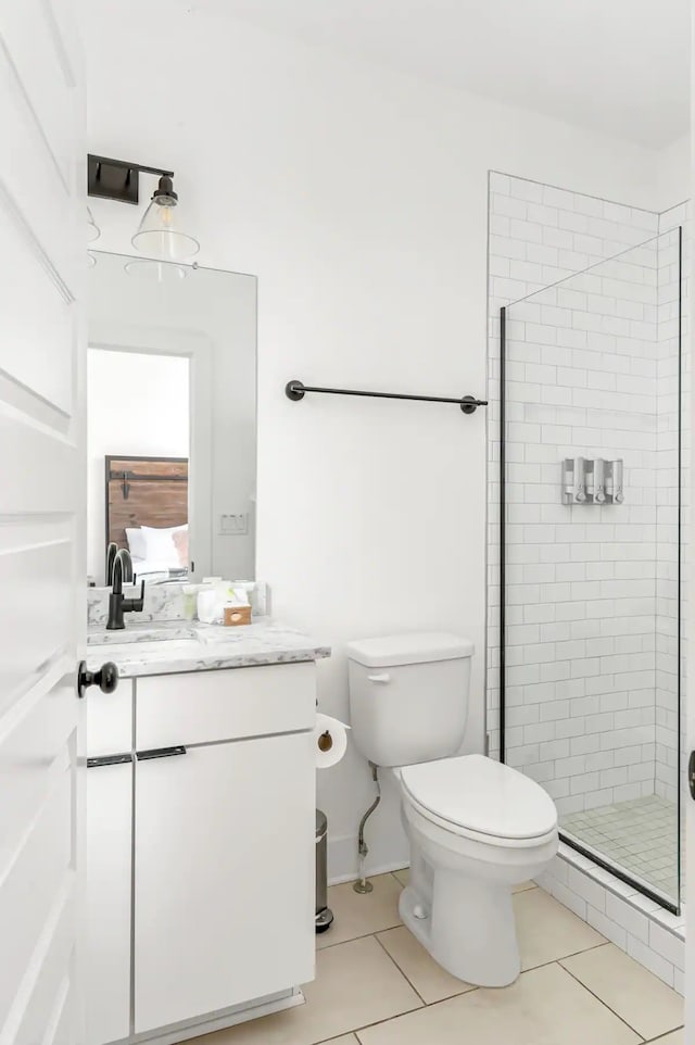 bathroom featuring toilet, vanity, tile patterned floors, and walk in shower