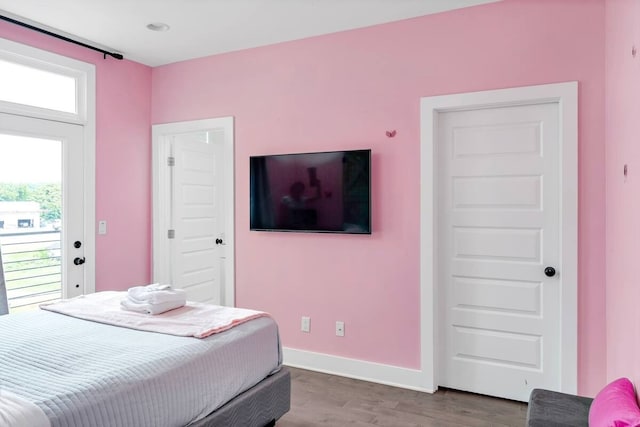 bedroom with wood-type flooring and access to outside