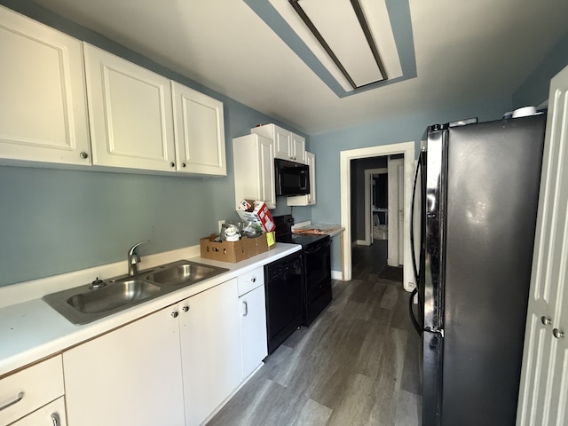 kitchen with dark wood-type flooring, white cabinetry, sink, and black appliances