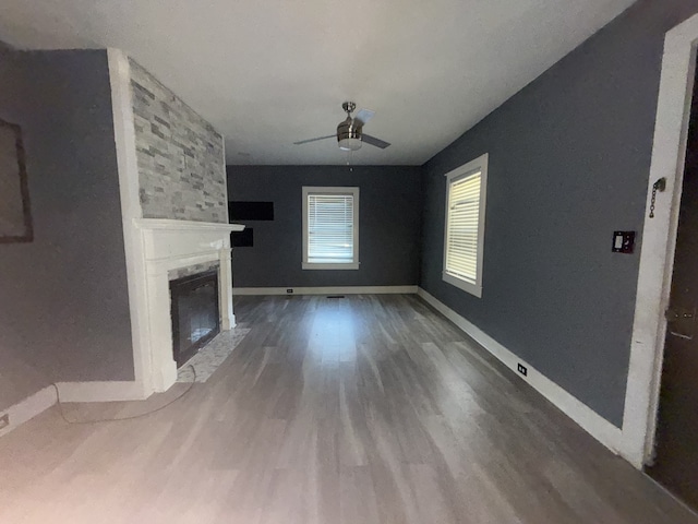 unfurnished living room featuring a fireplace, hardwood / wood-style flooring, and ceiling fan