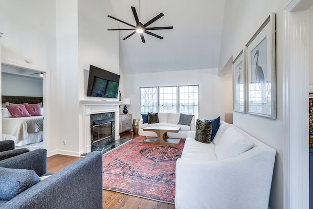 living room with high vaulted ceiling, hardwood / wood-style floors, ceiling fan, and a premium fireplace