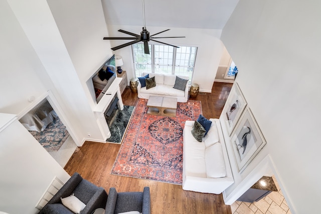 living room featuring dark wood-type flooring, high vaulted ceiling, and ceiling fan