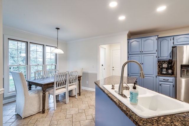 kitchen with stainless steel fridge, crown molding, blue cabinetry, pendant lighting, and sink