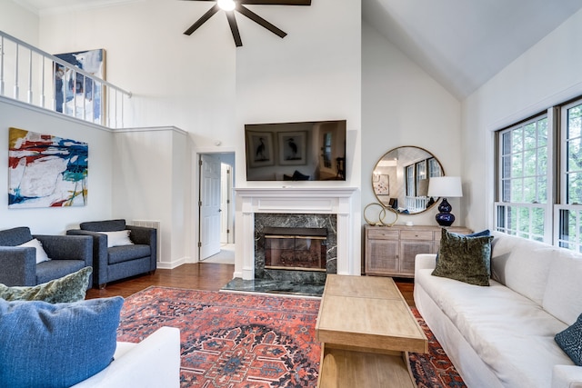 living room featuring a fireplace, dark hardwood / wood-style flooring, ceiling fan, and high vaulted ceiling