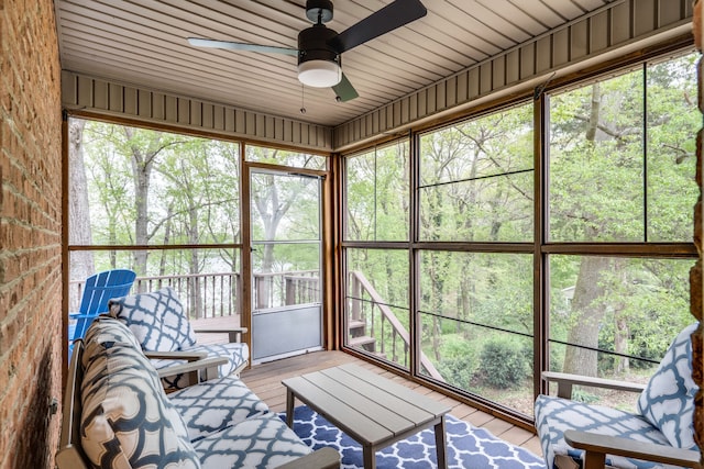 unfurnished sunroom featuring wood ceiling and ceiling fan