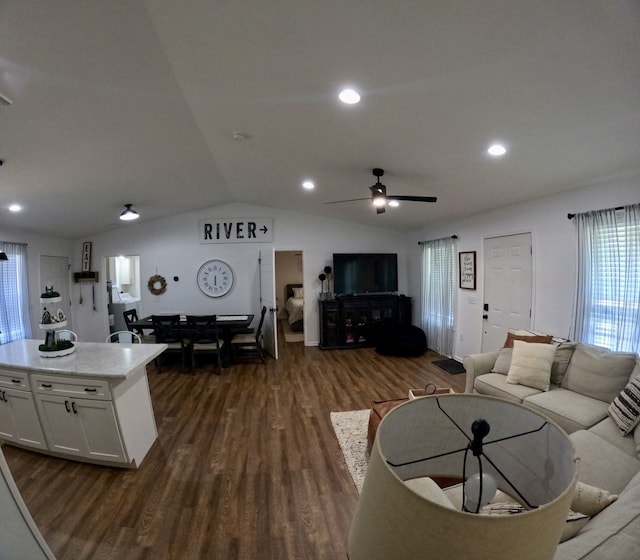 living room featuring dark wood-type flooring, ceiling fan, and vaulted ceiling