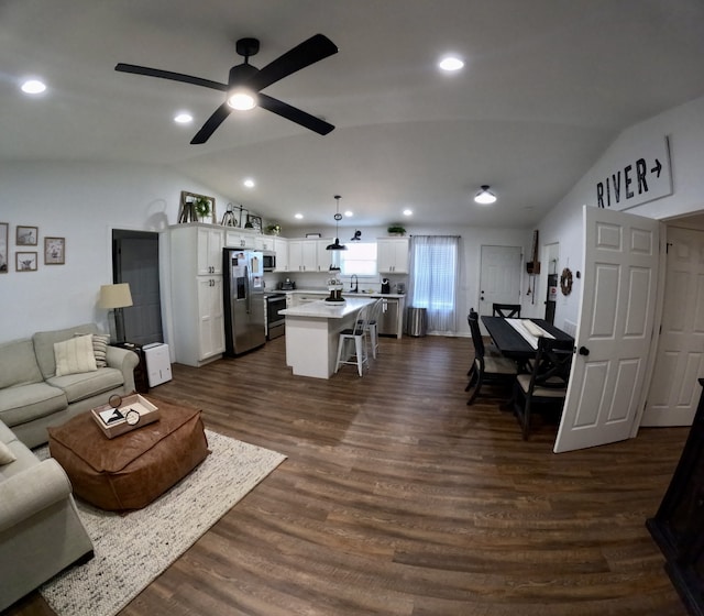 living room featuring lofted ceiling, dark wood-type flooring, ceiling fan, and sink