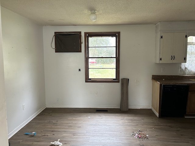 unfurnished dining area featuring hardwood / wood-style floors and a textured ceiling