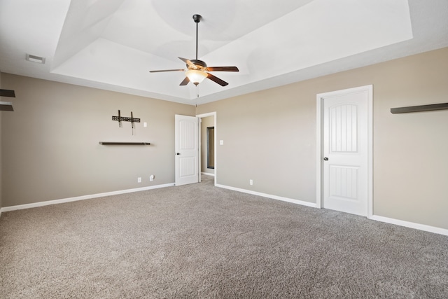 unfurnished bedroom featuring carpet flooring, a raised ceiling, and ceiling fan