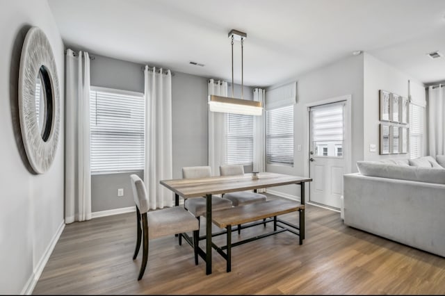 dining space with a wealth of natural light and dark hardwood / wood-style floors