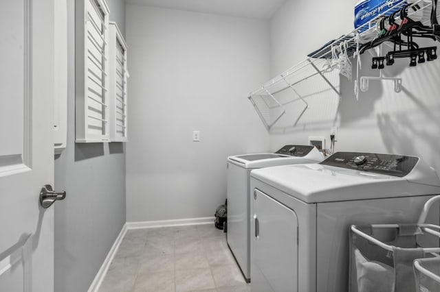 laundry room with light tile patterned floors and washer and clothes dryer