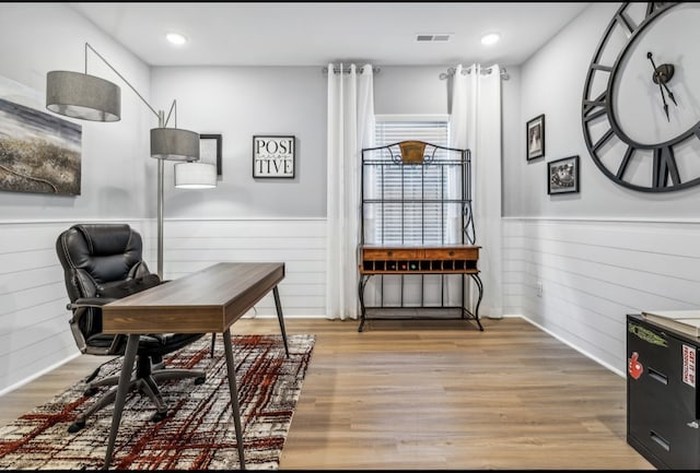 office space featuring light hardwood / wood-style flooring, wood walls, and plenty of natural light