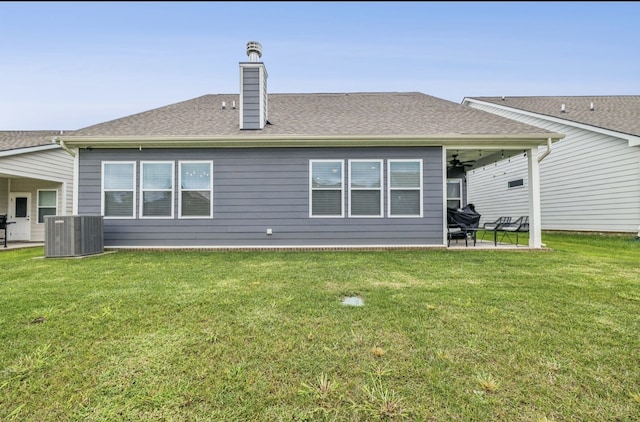 rear view of house featuring central AC unit, a patio, ceiling fan, and a yard