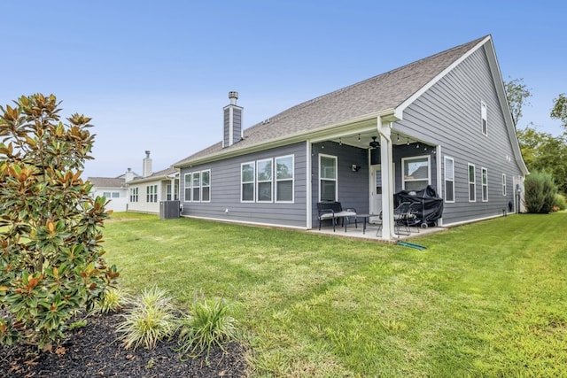 back of property featuring central air condition unit, a lawn, and a patio area