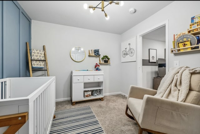 bedroom featuring a crib, light carpet, and an inviting chandelier