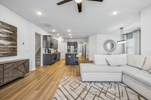 living room with ceiling fan and light hardwood / wood-style floors