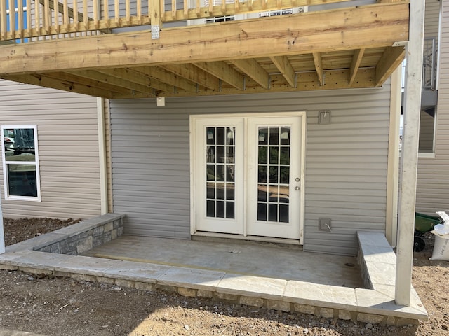 view of exterior entry featuring a deck and a patio area