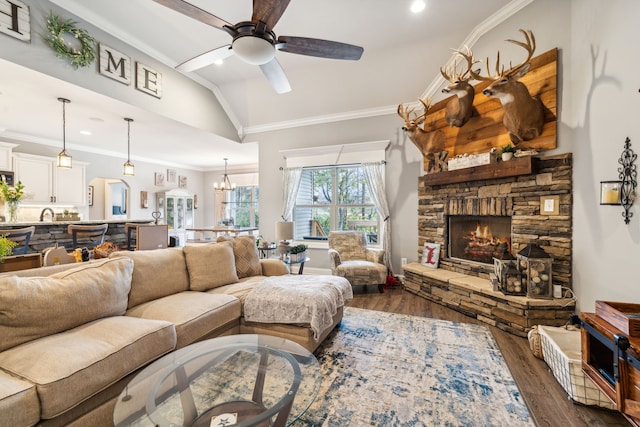 living room featuring dark wood-type flooring, a stone fireplace, and crown molding