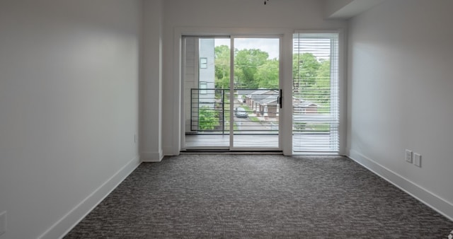 spare room featuring dark carpet