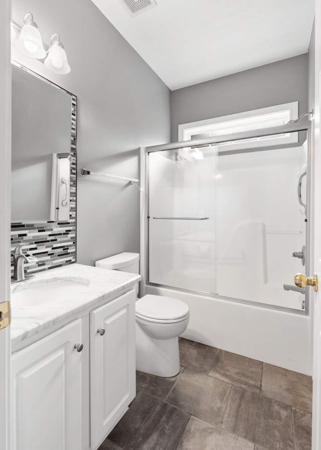 full bathroom featuring enclosed tub / shower combo, vanity, toilet, and tasteful backsplash