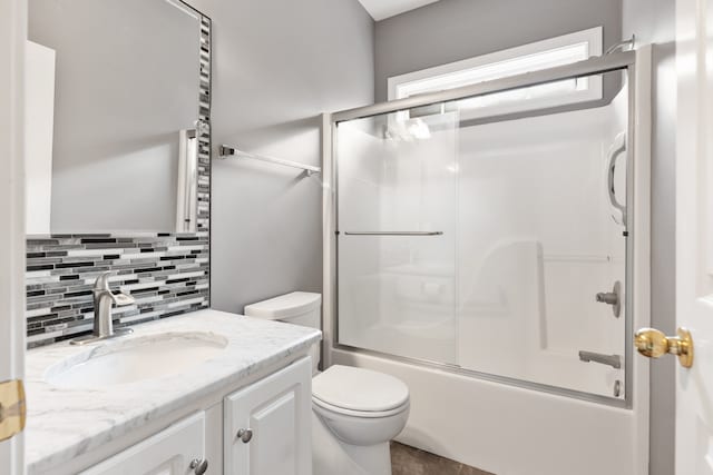 full bathroom with toilet, tile patterned flooring, tasteful backsplash, shower / bath combination with glass door, and vanity