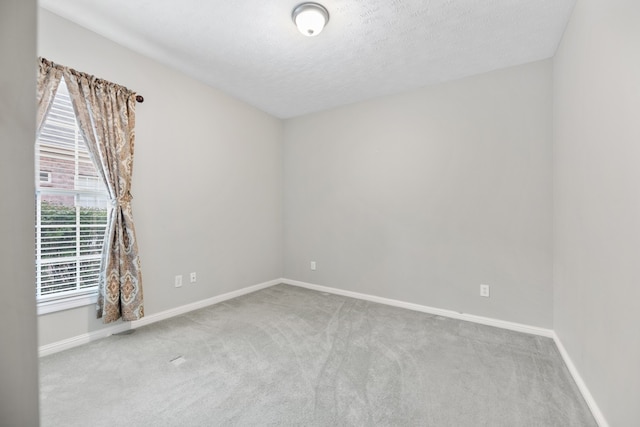 carpeted empty room featuring a textured ceiling