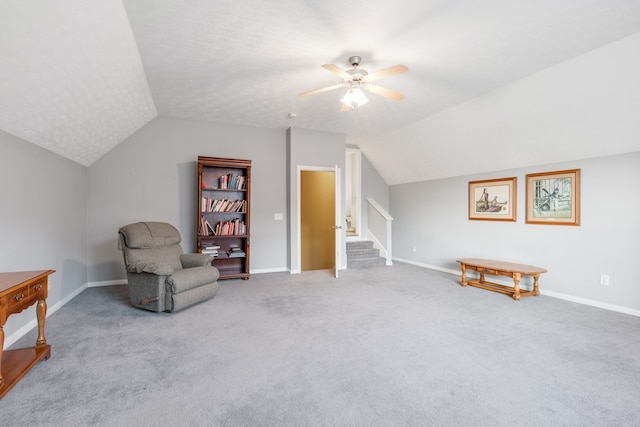 sitting room with vaulted ceiling, light carpet, and ceiling fan