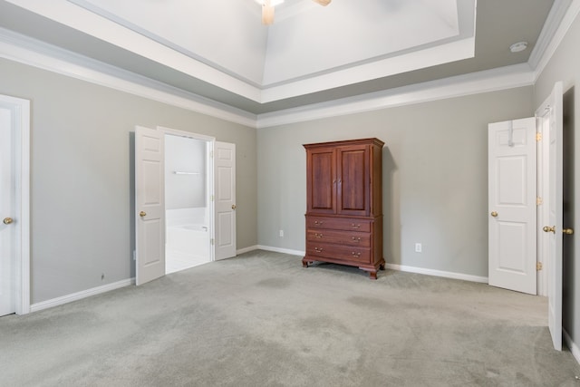 unfurnished bedroom featuring ceiling fan, light colored carpet, crown molding, and a tray ceiling