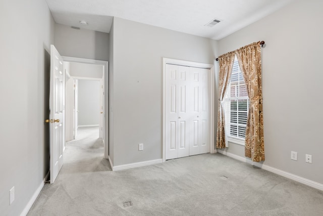 unfurnished bedroom featuring a closet and light carpet