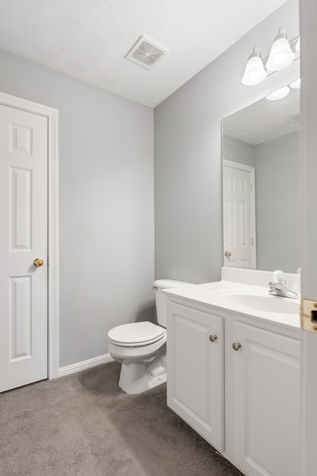 bathroom featuring vanity, a textured ceiling, and toilet