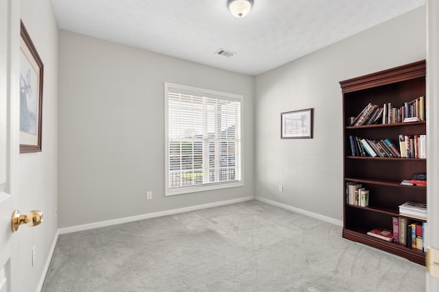 unfurnished room featuring light colored carpet and a textured ceiling