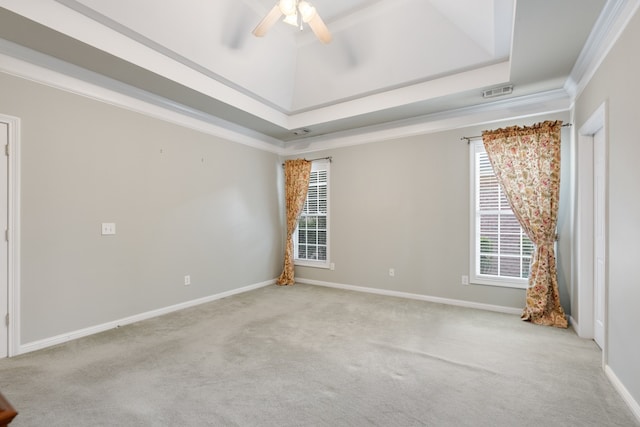 carpeted spare room with ceiling fan, a tray ceiling, and ornamental molding