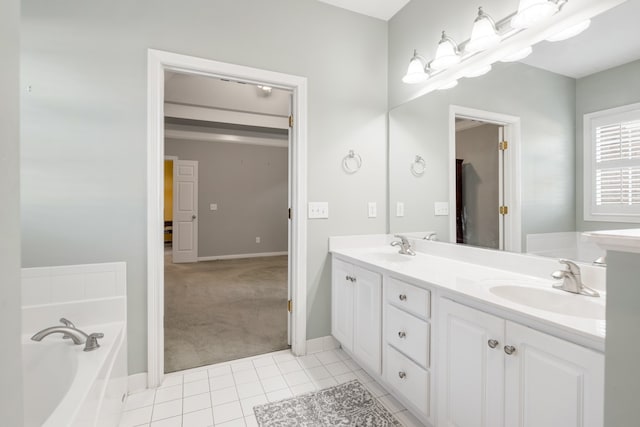 bathroom with a tub to relax in, vanity, and tile patterned flooring