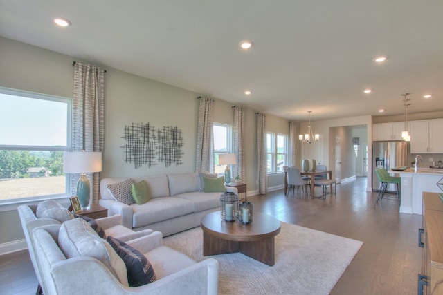 living room with a notable chandelier and dark hardwood / wood-style floors