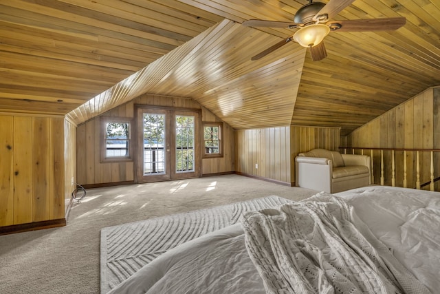 unfurnished bedroom featuring wood ceiling, light colored carpet, vaulted ceiling, ceiling fan, and wooden walls