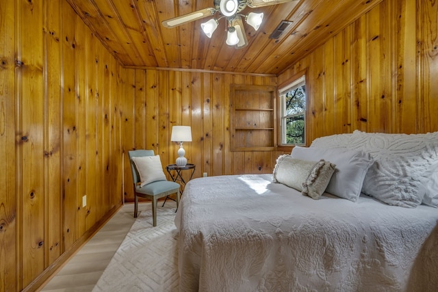 bedroom featuring wooden walls, ceiling fan, light hardwood / wood-style floors, and wooden ceiling