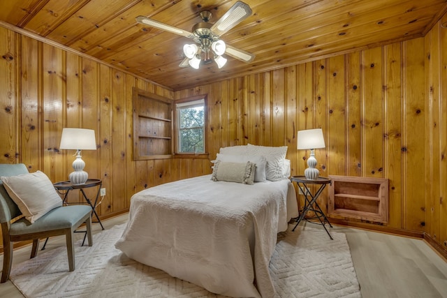 bedroom featuring light hardwood / wood-style floors, ceiling fan, wooden ceiling, and wood walls