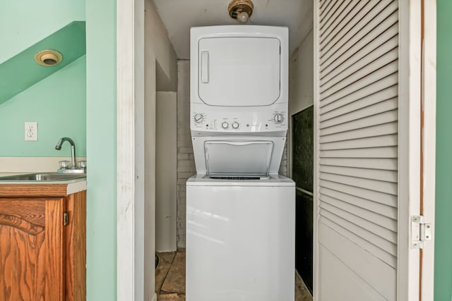 washroom featuring stacked washer and clothes dryer, sink, and tile patterned flooring