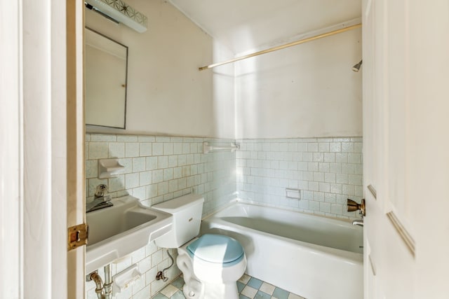 bathroom with toilet and tile walls