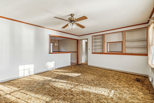 carpeted spare room featuring built in features, ceiling fan with notable chandelier, and crown molding