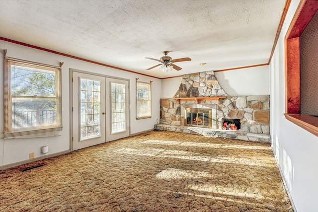 unfurnished living room with ornamental molding, a wealth of natural light, a textured ceiling, and carpet