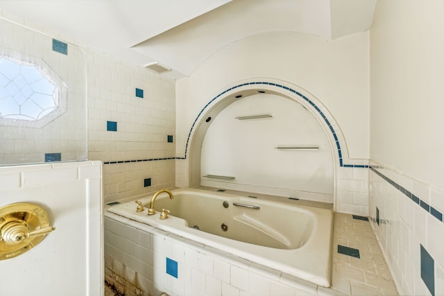 bathroom featuring tile walls, tiled tub, and tile patterned floors