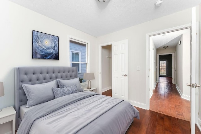 bedroom with a textured ceiling and dark wood-type flooring