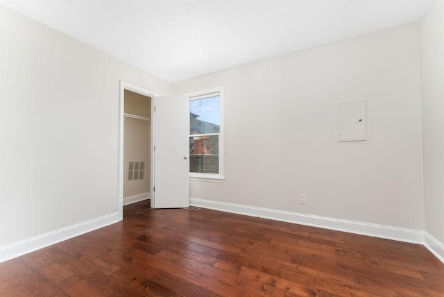 unfurnished bedroom with electric panel and dark wood-type flooring