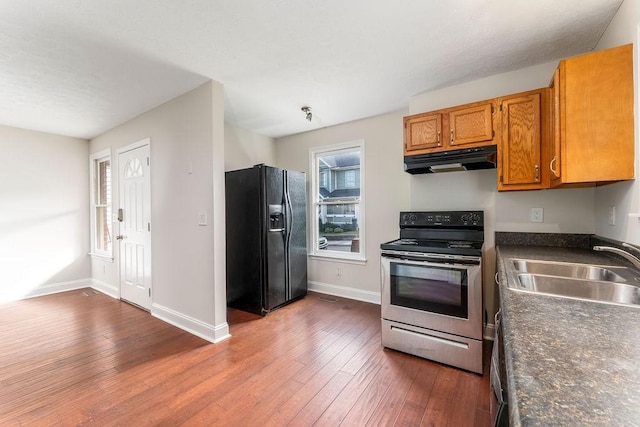 kitchen with electric range, dishwasher, sink, dark wood-type flooring, and black fridge with ice dispenser