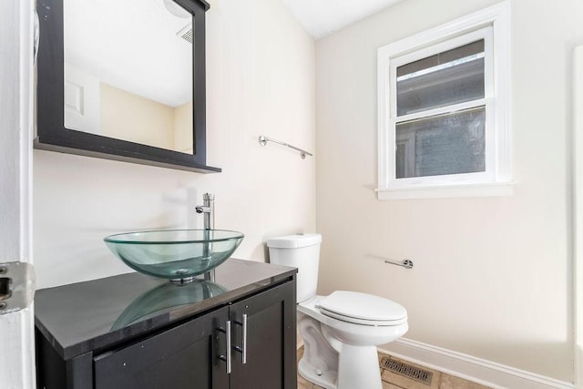 bathroom featuring tile patterned flooring, vanity, and toilet