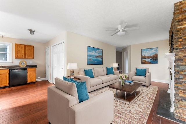 living room with ceiling fan, a fireplace, and dark wood-type flooring